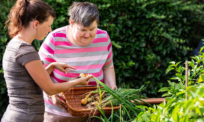 A carer helping a woman garden